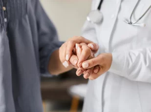 врач держит женщину за руку