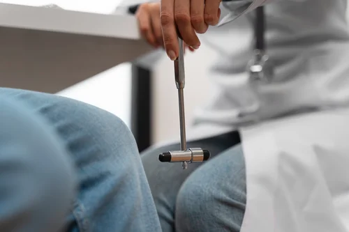 врач-невролог с тромнером в руке